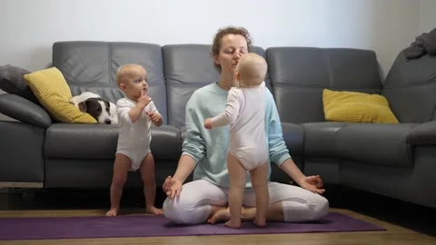 A mother trying to focus and practice yoga while her twin babies keep bothering Video stock 150568389