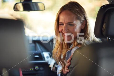 Mother Turning Round To Talk To Children In Back Seat On Car Journey Stock Photos