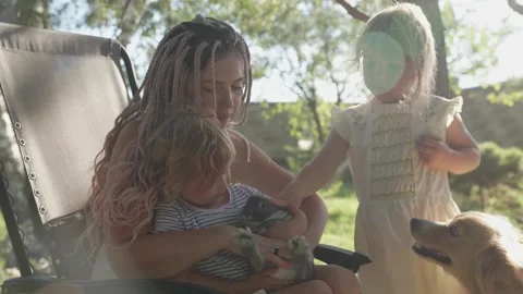 A mother with two daughters, a rabbit and a dog. Family communication. Video stock 283075350