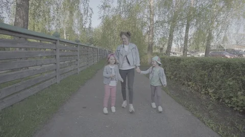 Mother with two daughters walking in the Park in the evening Stock Footage 130172477