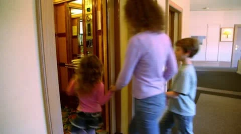 Mother with two kids walk in elevator, then doors closes Stock Footage 10856331