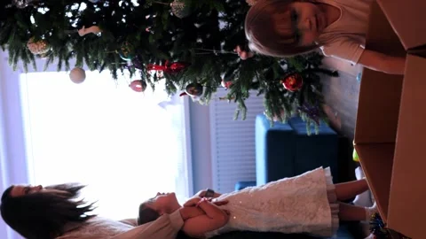 Mother with two pretty daughters decorating Christmas tree at home Stock Footage 256713959