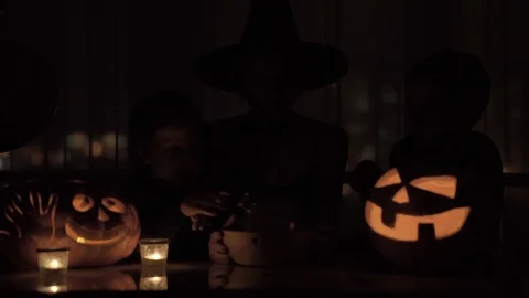 Mother with two sons playing a witch on Halloween. With a magic lamp and a Stock Footage 119525002