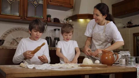 Mother with two sons is preparing a dough in domestic kitchen Stock Footage 133582028