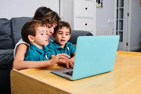 A mother using a computer to teach their children at home Stock Photos