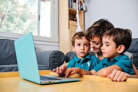 A mother using a computer to teach their children at home Stock Photos