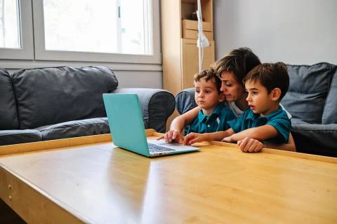 A mother using a computer to teach their children at home Stock Photos