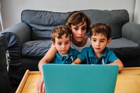 A mother using a computer to teach their children at home Stock Photos