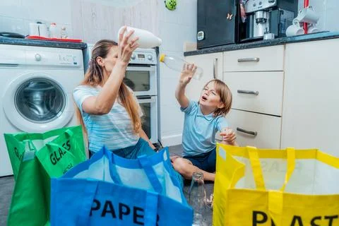 Mother using game is teaching kid how to recycle help the boy aware Stock Photos