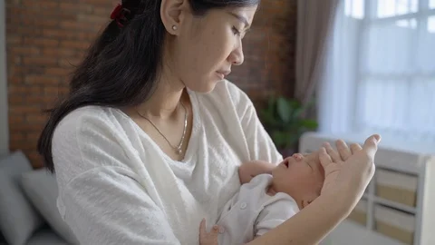 Mother using her hand to feel newborn baby skin temperature Stock Footage 120273682