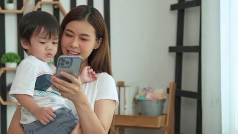 Mother using her smartphone to open some social media for son. Stock Footage 204962920