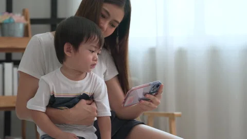 Mother using her smartphone to turn on the music and get son dancing. Stock Footage 204963510