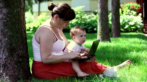  Mother using laptop with son  Stock Footage 64947723