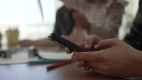 Mother using smart phone while family plays and draws Stock Footage 333261669