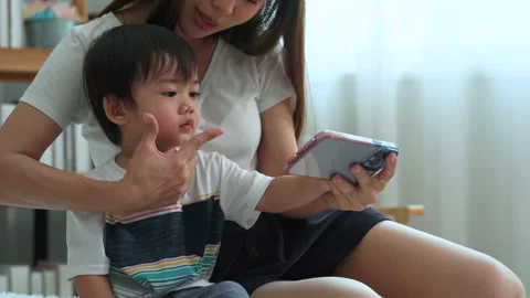Mother using smartphone to show social media to her son. Stock Footage 204963512