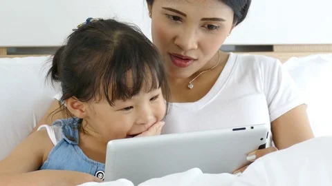 Mother using tablet computer with her daughter Stock Footage 77116598