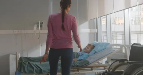 Mother visiting son lying in bed in hospital ward Video stock 154132733