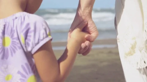 Mother walking hand in hand with little girl walking slow motion closeup Stock Footage 80308422