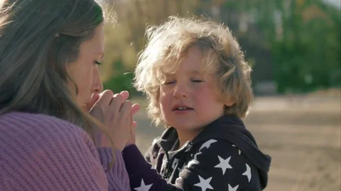 Mother warms her son's hands on the beach Stock-Footage 76014036