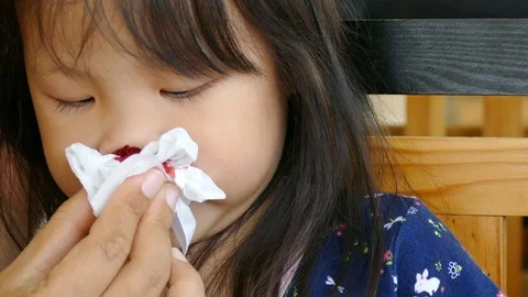 Mother wipe her daughter's bleeding nose by paper Stock Footage 76817196