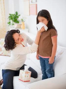 Mother wiping sick daughterís nose with tissue mother wiping sick daughters nos Stock Photos