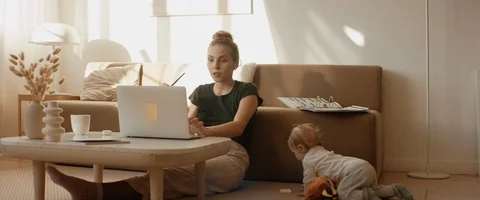 Mother working from home, having a work video call, daughter playing nearby Video stock 127374218
