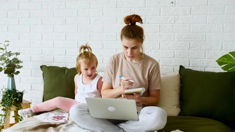 Mother working from home, having a work video call and child playing nearby Video stock 162950607