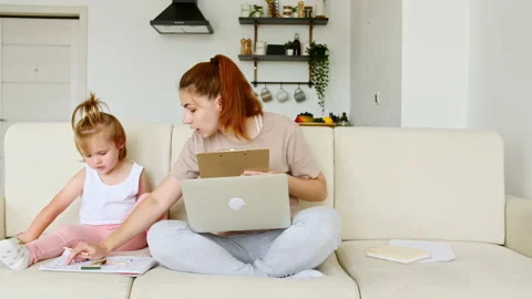 Mother working from home, having a work video call, phone call and child playing 스톡 동영상 165194318