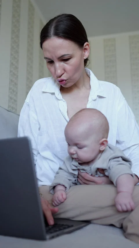 Mother working from home while holding her baby Video stock 313926587