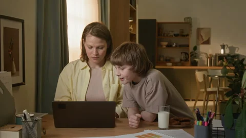 Mother Working Remotely, Son Coming up to Desk and Taking Bite of Cookie Stock Footage 313744770