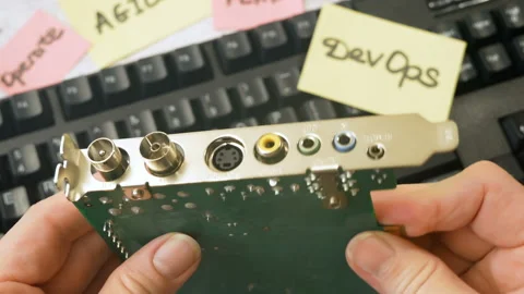 Motherboard and sticker devops rotate on wooden background, devops Stock Footage 160811225