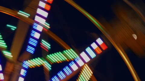 Motin Blurred Illuminated Ferris Wheel and Moon Stock Footage 41592953