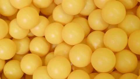 Motion above yellow plastic balls with falling pieces Stock Footage 137436386