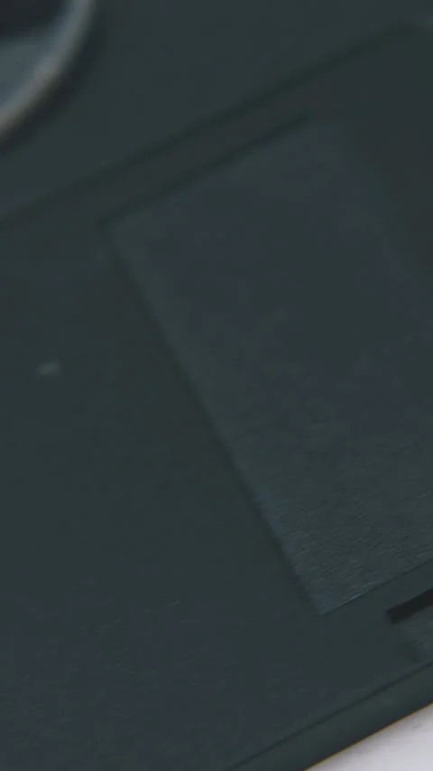 Motion along floppy disk in black case on white surface Video stock 317384051