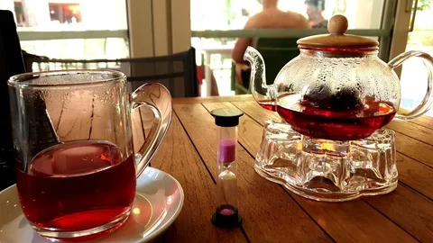 Motion along table with teapot tea cup and hourglass Stock Footage 110990739