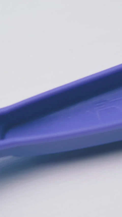Motion along violet disposable fork on white background Stock Footage 317385820