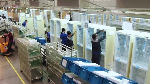 Motion along workshop with people assembling fridges Stock Footage 108656919