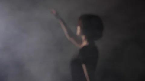 Motion around lady extending hand to light rays in fog Stock Footage 115257020