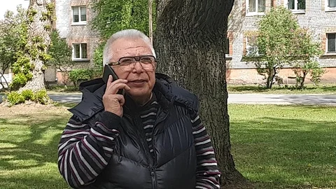 Motion around senior man using mobile phone in city garden Stock Footage 112416669