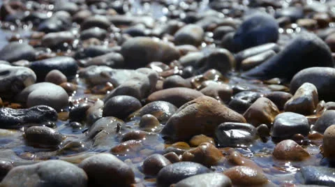 Motion Backgrounds : Shimmering sunlight on stony shore Stock Footage 26418556