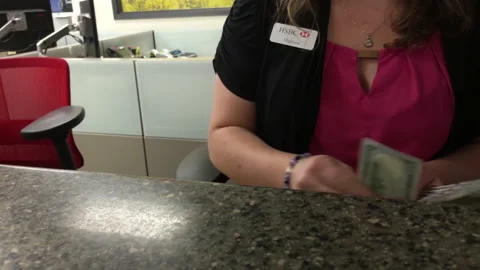 Motion of bank teller counting US dollar for a customer inside HSBC Bank Stock Footage 143228741