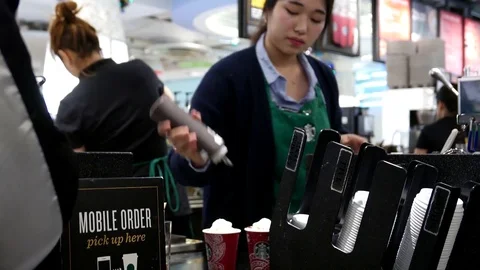 Motion of barista making coffee for customer at Starbucks store 動画素材 70975559