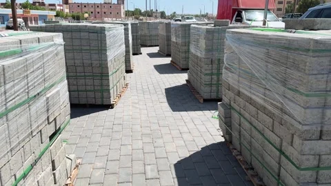 Motion between stacks of concrete paving tiles prepared for urban sidewalk Stock Footage 341840224