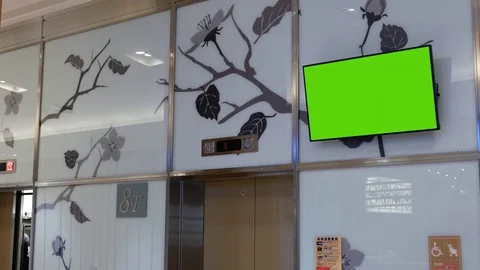 Motion of big green screen tv on wall inside shopping mall Stock Footage 82771806