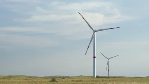 Motion the blades of a large wind turbine in a field against a background of Stock Footage 155394095