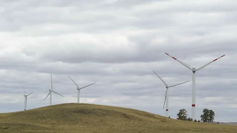 Motion the blades of a large wind turbine in a field against a background of Stock Footage 160318282