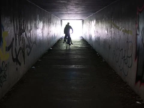 With motion blur and strong backlight, two youths on a cycle leave a subway Stock Photos