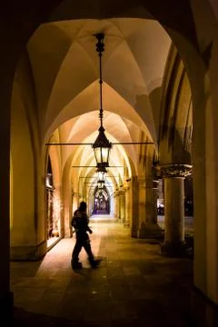 Motion blur of man walking through the columns at sukiennice Cloth Hall at ni Stock Photos