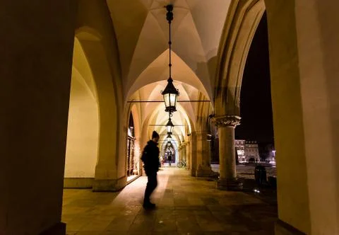 Motion blur of man walking through the columns at sukiennice Cloth Hall at ni Fotos de archivo