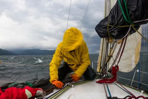 Motion blur men work with cord of sails of a yacht in the difficult storm sea Stock Photos